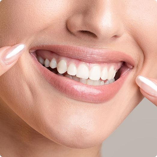 Close up of woman pointing to her smile